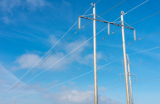 power wiring against blue sky during winter