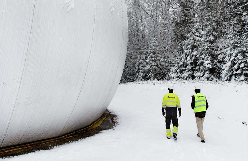 Biokaasulaitoksen henkilökuntaa laitosalueella. 