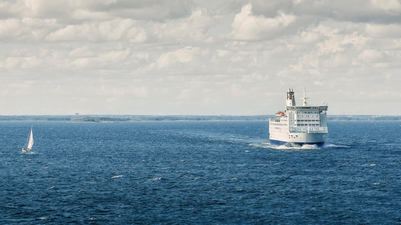 Cargo ship sailing on open sea under EU maritime emission regulations.