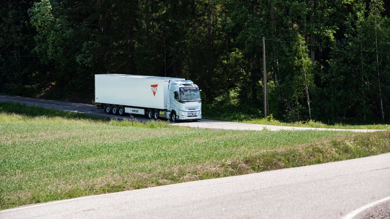 Biogas powered truck in green scenery.