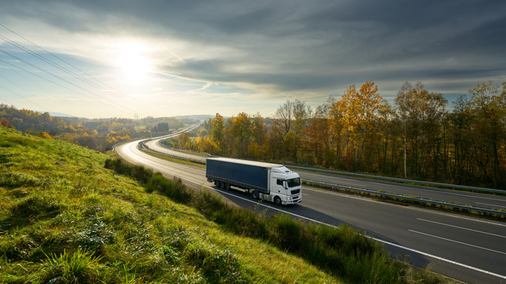 Truck on the road during autumn sunset