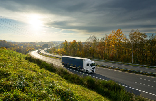 Truck on the road during autumn sunset